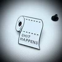 A toilet paper roll pin saying shit happens